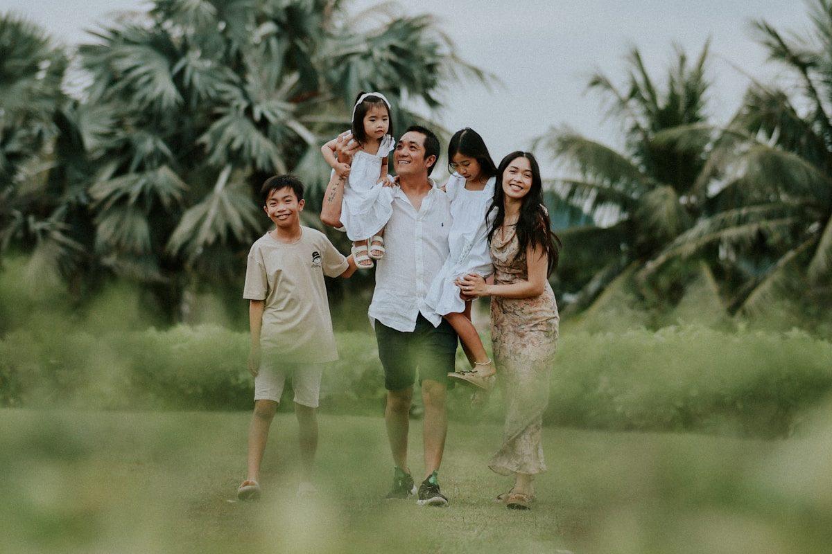 A family walking together in a grassy field.